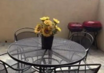 a glass table with a vase of yellow flowers on it at Magicway Villas Mini's Poolside and Spa - Across Disneyland in Anaheim