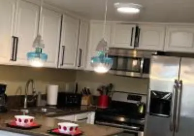 a kitchen with white cabinets and pink bowls on the counter at Magicway Villas Mini's Poolside and Spa - Across Disneyland in Anaheim