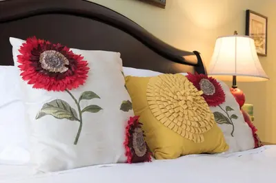 two pillows with flowers on a bed with a lamp at Magicwayvillas Micky's Playground Pool & Spa - Walking TO Disney in Anaheim