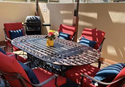 a table with chairs and a vase of flowers on it at MagicwayVillas Mick's ClockHouse Pool & Spa - Walk to Disneyland in Anaheim
