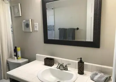 a bathroom with a sink and a mirror and a toilet at Magicwayvillas Micky's HideAway in Fullerton