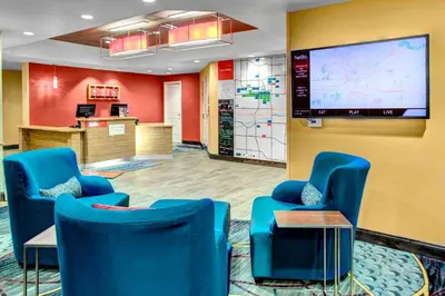 a waiting room with blue chairs and a large screen at TownePlace Suites by Marriott Bakersfield West in Bakersfield