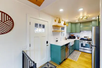 a kitchen with green and white cabinets and a refrigerator at Arosa Pines in Crestline