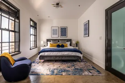 a bedroom with a bed and a blue chair at Urban Luxe LOFT in Los Angeles