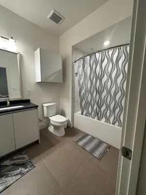 a bathroom with a shower and a toilet and a sink at Avalon Wilshire in Los Angeles