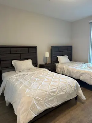 a bedroom with two beds with white comforter at Avalon Wilshire in Los Angeles
