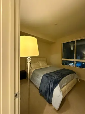 a bedroom with a bed with a lamp and a window at Wilshire La Brea Apartments in Los Angeles
