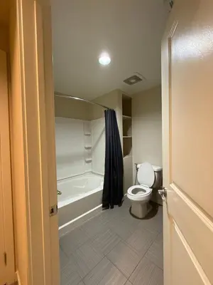 a bathroom with a toilet and a bath tub at Wilshire La Brea Apartments in Los Angeles
