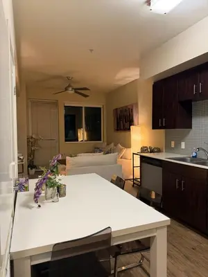 a kitchen and living room with a table and a couch at Wilshire La Brea Apartments in Los Angeles