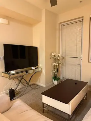 a living room with a tv and a coffee table at Wilshire La Brea Apartments in Los Angeles