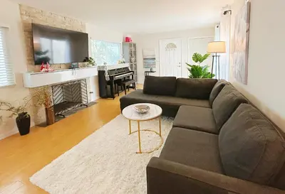 a living room with a couch and a fireplace at Brea Mall romantic two-bedroom house in Fullerton