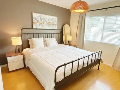 a bedroom with a bed and two lamps and a window at Brea Mall romantic two-bedroom house in Fullerton