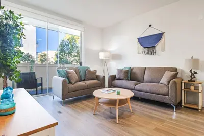 a living room with two couches and a table at Spacious 2BDR in SM - 5 minutes walk to the beach! in Los Angeles