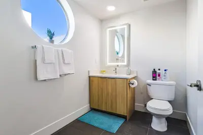 a bathroom with a toilet and a sink and a window at Spacious 2BDR in SM - 5 minutes walk to the beach! in Los Angeles