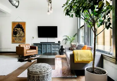 a living room with a couch and a tv at City Lights Loft Downtown LA Month Plus in Los Angeles