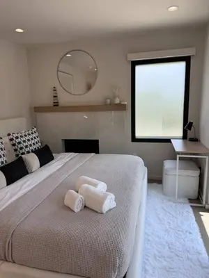 a bedroom with a large bed with towels on it at Zenice Beach Luxury Home - Sauna, Cold Plunge, Spa in Los Angeles