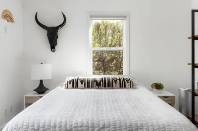 a white bedroom with a bed and a window at Sun-Drenched Spanish Manor Home in Mar Vista in Los Angeles