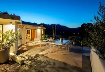 a patio with a table and chairs on a house at Hillside Hideaway with Deck And Spa in Topanga Canyon in Topanga