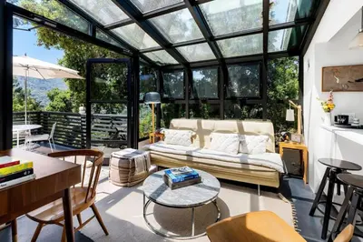 a conservatory with a couch and a table and chairs at Canyon Crest Cottage and Garden in Topanga Canyon in Topanga
