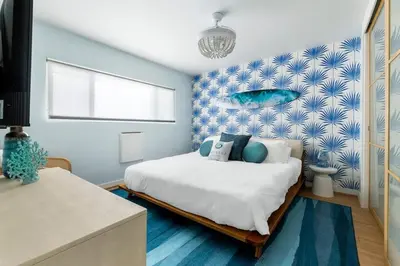 a bedroom with a bed and a blue wall at Breathe Malibu Ocean Front Condo with Beach Access in Malibu