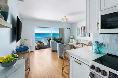 a kitchen and living room with a view of the ocean at Breathe Malibu Ocean Front Condo with Beach Access in Malibu