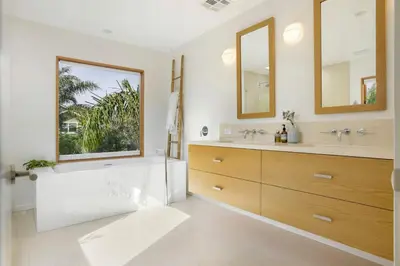 a bathroom with a tub and a sink and a mirror at San Juan Featured in Architectural Digest Plus Sauna in Los Angeles