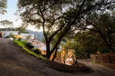 a group of people standing next to a dirt road with trees at Hillside Hideaway Guest House in Topanga Canyon in Topanga
