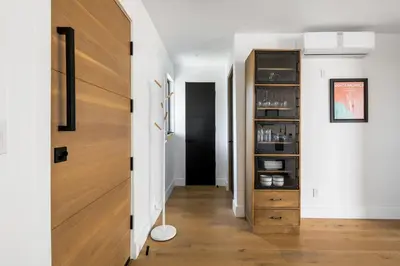 a hallway with white walls and a wooden door at Westminster Bungalow - Front House with Private Entrance in Los Angeles