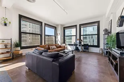 a living room with a couch and some windows at Skyline View Loft w Kitchen DTLA Exclusively Month Plus in Los Angeles
