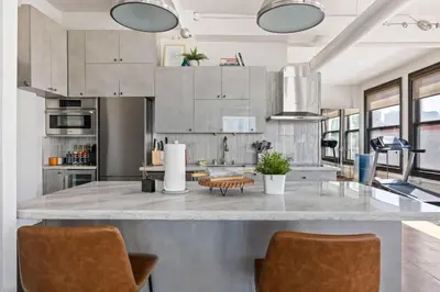 a kitchen with a large counter with two chairs at Skyline View Loft w Kitchen DTLA Exclusively Month Plus in Los Angeles