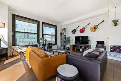 a living room with two couches and guitars on the wall at Skyline View Loft w Kitchen DTLA Exclusively Month Plus in Los Angeles
