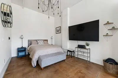 a bedroom with a bed and a flat screen tv at Skyline View Loft w Kitchen DTLA Exclusively Month Plus in Los Angeles