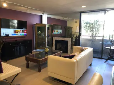 a living room with a white couch and a fireplace at Best Location West LA Spacious condo with hottub in Los Angeles