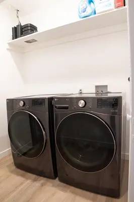 a black washer and dryer sitting under a counter at A Brand New Home In Los Angeles in Van Nuys County Court Heliport