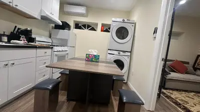 a kitchen with a table and a washing machine at 2B2B quiet comfy home in Hacienda Heights