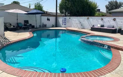 a swimming pool with blue water in a yard at Tranquil Poolside Oasis with BBQ and Serene Ambiance in North Hollywood