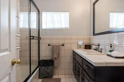 a bathroom with a shower and a sink and a mirror at Tranquil Poolside Oasis with BBQ and Serene Ambiance in North Hollywood