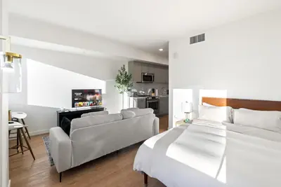 a white bedroom with a bed and a couch at Bright Studio on Sunset Blvd, Free Parking, Gym, and Pool in Los Angeles