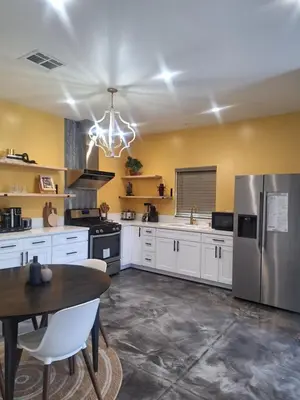 a kitchen with white cabinets and a stainless steel refrigerator at Azusa in Azusa