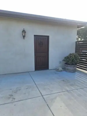 a front door of a white building with a light at Azusa in Azusa