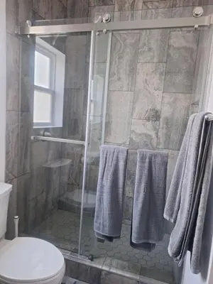 a bathroom with a shower with a toilet and towels at Beautiful and cosy home in Azusa