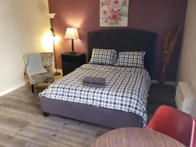 a bedroom with a bed and a chair and a table at Beverly Hills Suite with Balcony in Los Angeles