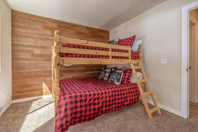 a bedroom with two bunk beds and a ladder at TimberWood Cabin- 3 Bdr - 2 Bth - Big Game room - Prime Location in Big Bear Lake in Big Bear Lake
