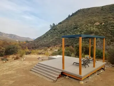 a wooden platform with a bench and an umbrella at Ojai Wilderness Off-The-Grid Sespe House in Ojai