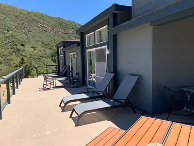 a deck with chairs and tables on a house at Ojai Wilderness Off-The-Grid Sespe House in Ojai