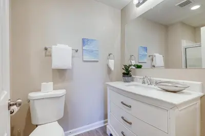 a white bathroom with a toilet and a sink at 2 Mi to Beaches Condo with Patio in Port Hueneme! in Port Hueneme