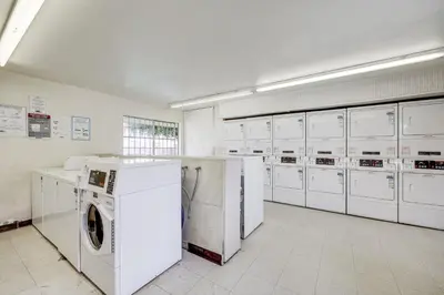 a large laundry room with white washers and dryers at 2 Mi to Beaches Condo with Patio in Port Hueneme! in Port Hueneme