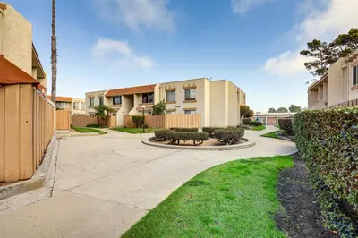 an apartment complex with a fence and a yard at 2 Mi to Beaches Condo with Patio in Port Hueneme! in Port Hueneme