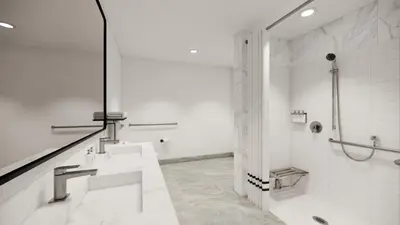 a white bathroom with two sinks and a shower at Kins Hotel in Los Angeles