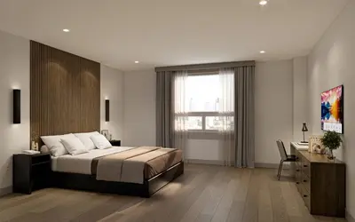 a bedroom with a bed and a desk and a window at Kins Hotel in Los Angeles